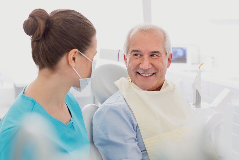 older man smiling at the dentist